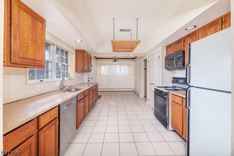 23 Old Denville Road Boonton, NJ 07005 - Photo 11 of 50 a kitchen with stainless steel appliances granite countertop a refrigerator a sink dishwasher a stove with wooden cabinets