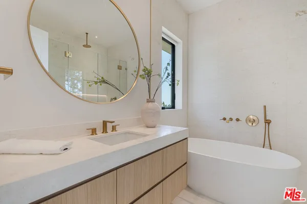 a bathroom with a sink a tub and a mirror