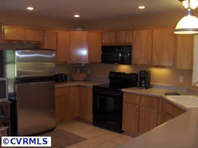 17419 Fox Branch Road Carson, VA 23830 - Photo 7 of 10 a kitchen with a refrigerator and a stove top oven