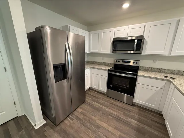 a kitchen with white cabinets and stainless steel appliances