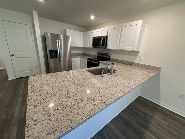 a kitchen with granite countertop counter top space cabinets stainless steel appliances and a counter top space