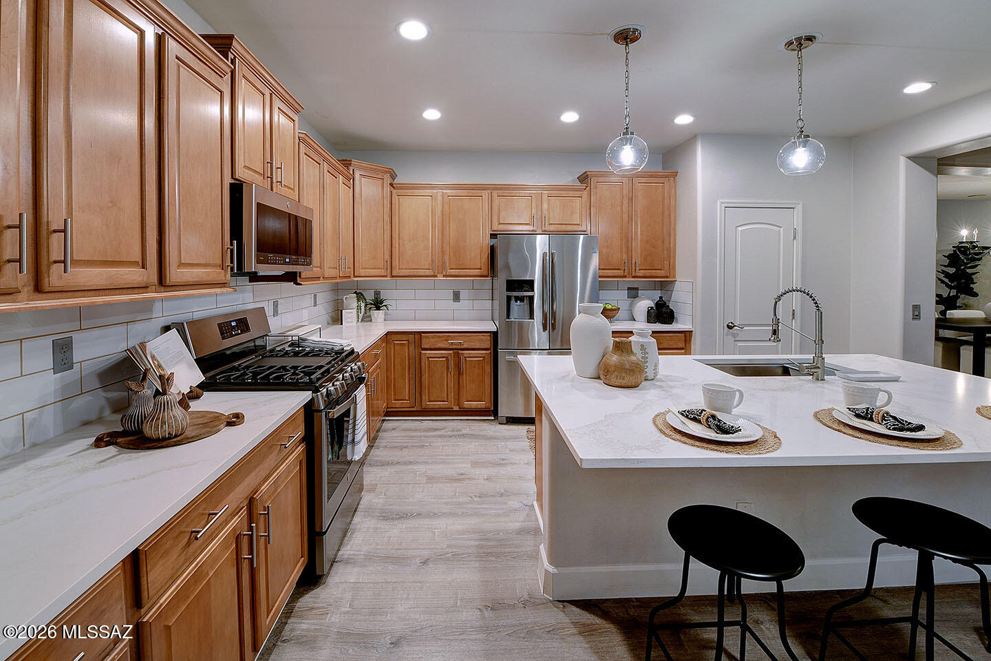 13464 North Piemonte Way Oro Valley, AZ 85755 - Photo 8 of 33 a kitchen with stainless steel appliances kitchen island granite countertop a sink a stove a refrigerator cabinets and chairs