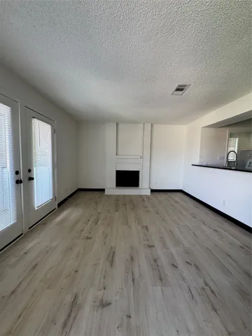 a view of a livingroom with wooden floor and fireplace