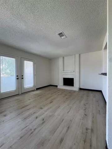 an empty room with wooden floor and fireplace