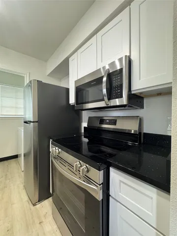 a kitchen with stainless steel appliances a stove a microwave and a sink