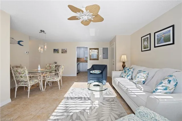 a living room with furniture a chandelier and a dining table