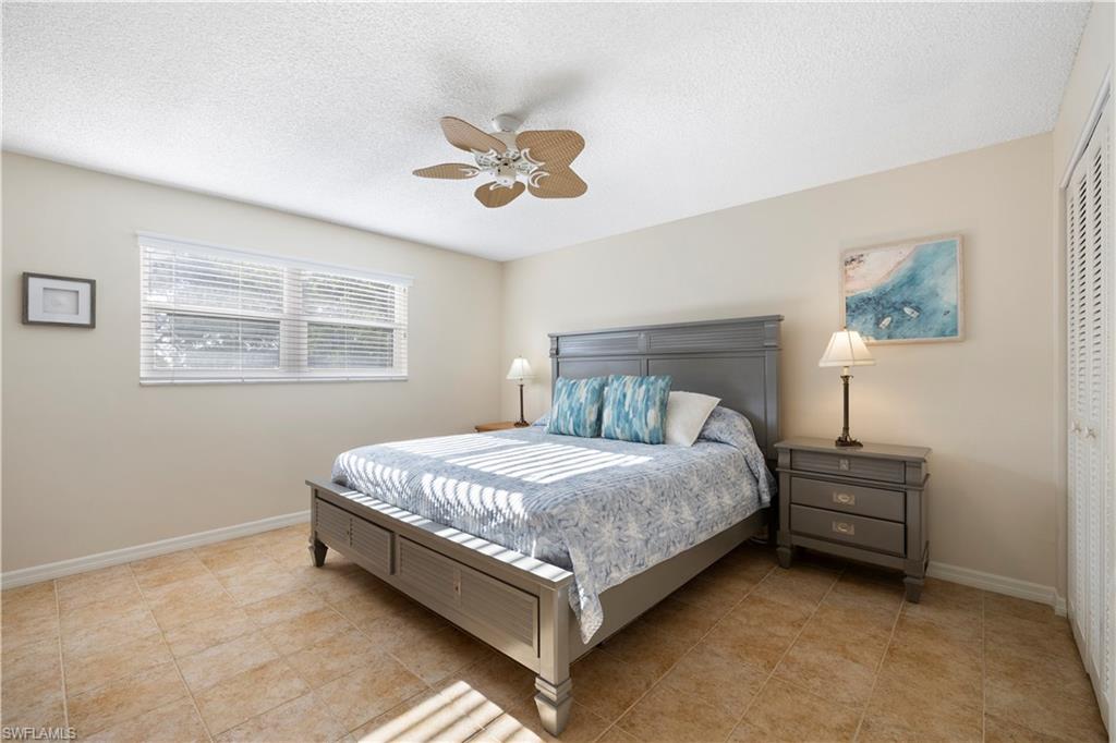 578 Broad Avenue South, Unit 578 Naples, FL 34102 - Photo 15 of 32 a bed sitting in a bedroom next to a window