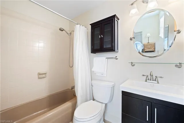 a bathroom with a toilet a sink a tub and mirror