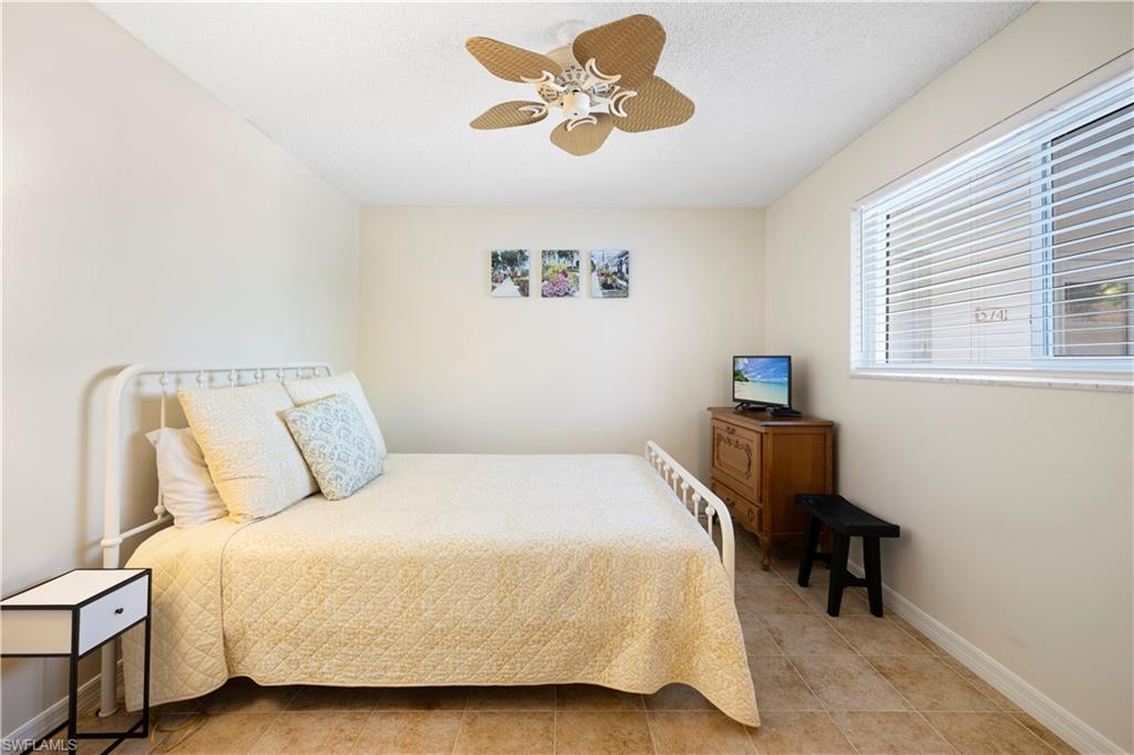 578 Broad Avenue South, Unit 578 Naples, FL 34102 - Photo 21 of 32 a bedroom with a bed and a table