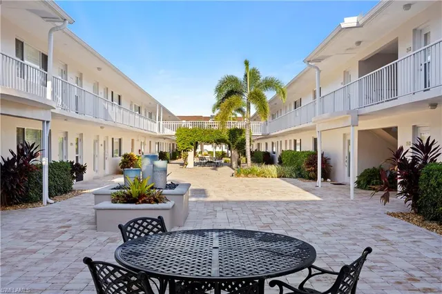 a view of a patio with couches and table and chairs potted plants