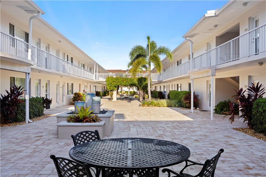 578 Broad Avenue South, Unit 578 Naples, FL 34102 - Photo 3 of 32 a view of a patio with couches and table and chairs potted plants