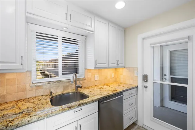 a kitchen with granite countertop a sink and a window