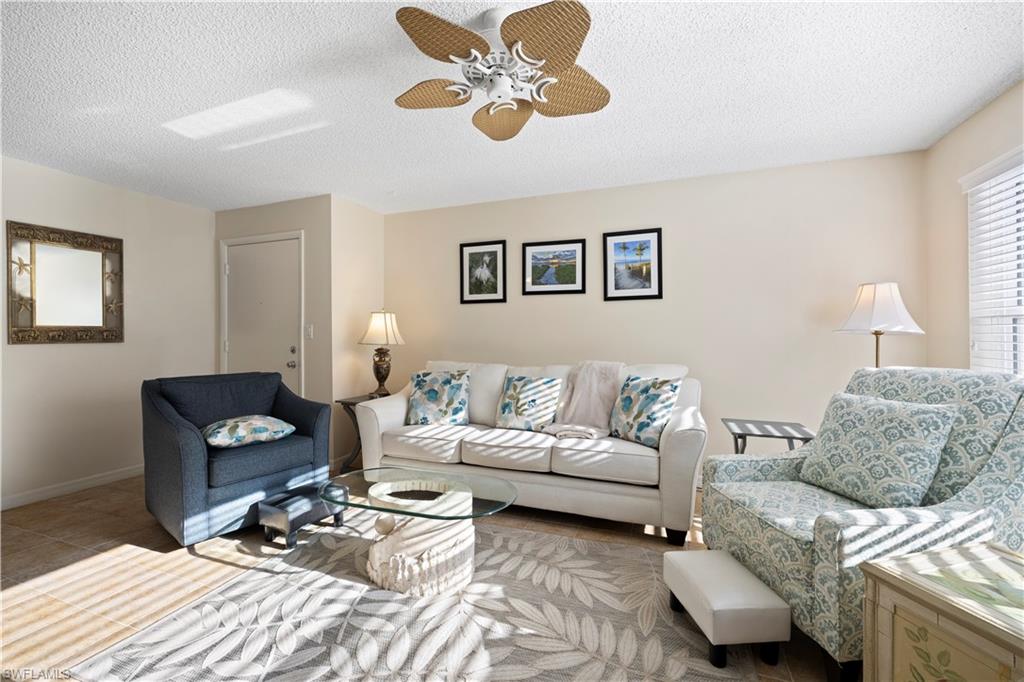578 Broad Avenue South, Unit 578 Naples, FL 34102 - Photo 9 of 32 a living room with furniture and a rug