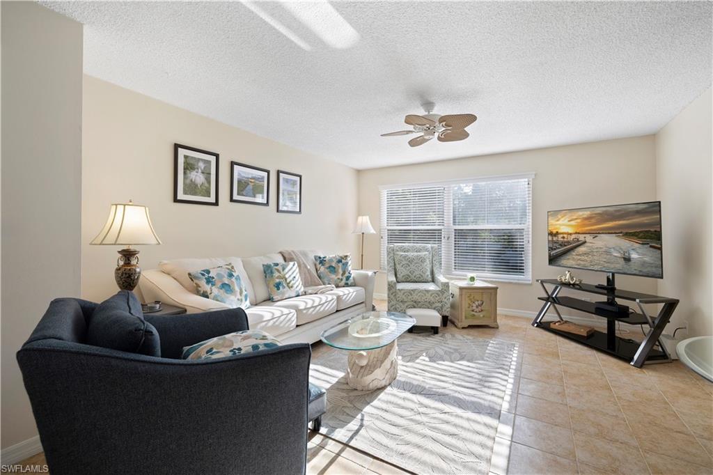 578 Broad Avenue South, Unit 578 Naples, FL 34102 - Photo 10 of 32 a living room with furniture and a flat screen tv