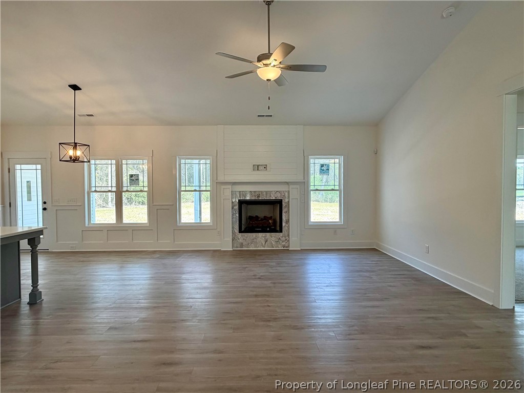 1788 Alderman Mill Road Dunn, NC 28334 - Photo 6 of 14 an empty room with wooden floor chandelier fan and windows