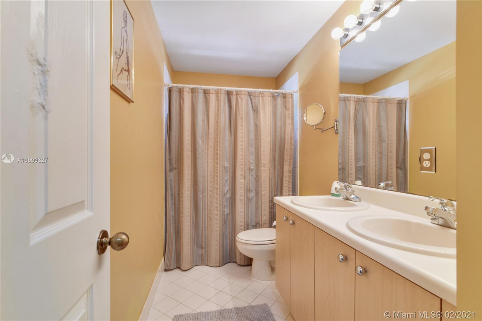 4100 Forest Drive, Unit 4100 Weston, FL 33332 - Photo 11 of 14 a bathroom with a sink a toilet and shower curtain