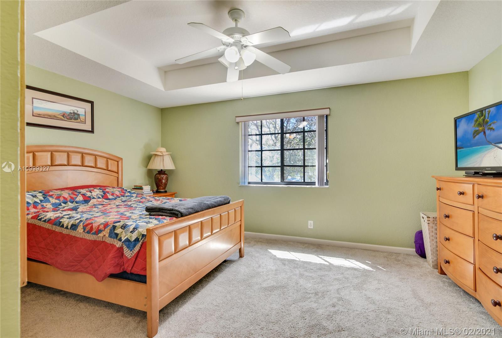 4100 Forest Drive, Unit 4100 Weston, FL 33332 - Photo 8 of 14 a bedroom with a bed and a flat tv screen on dresser