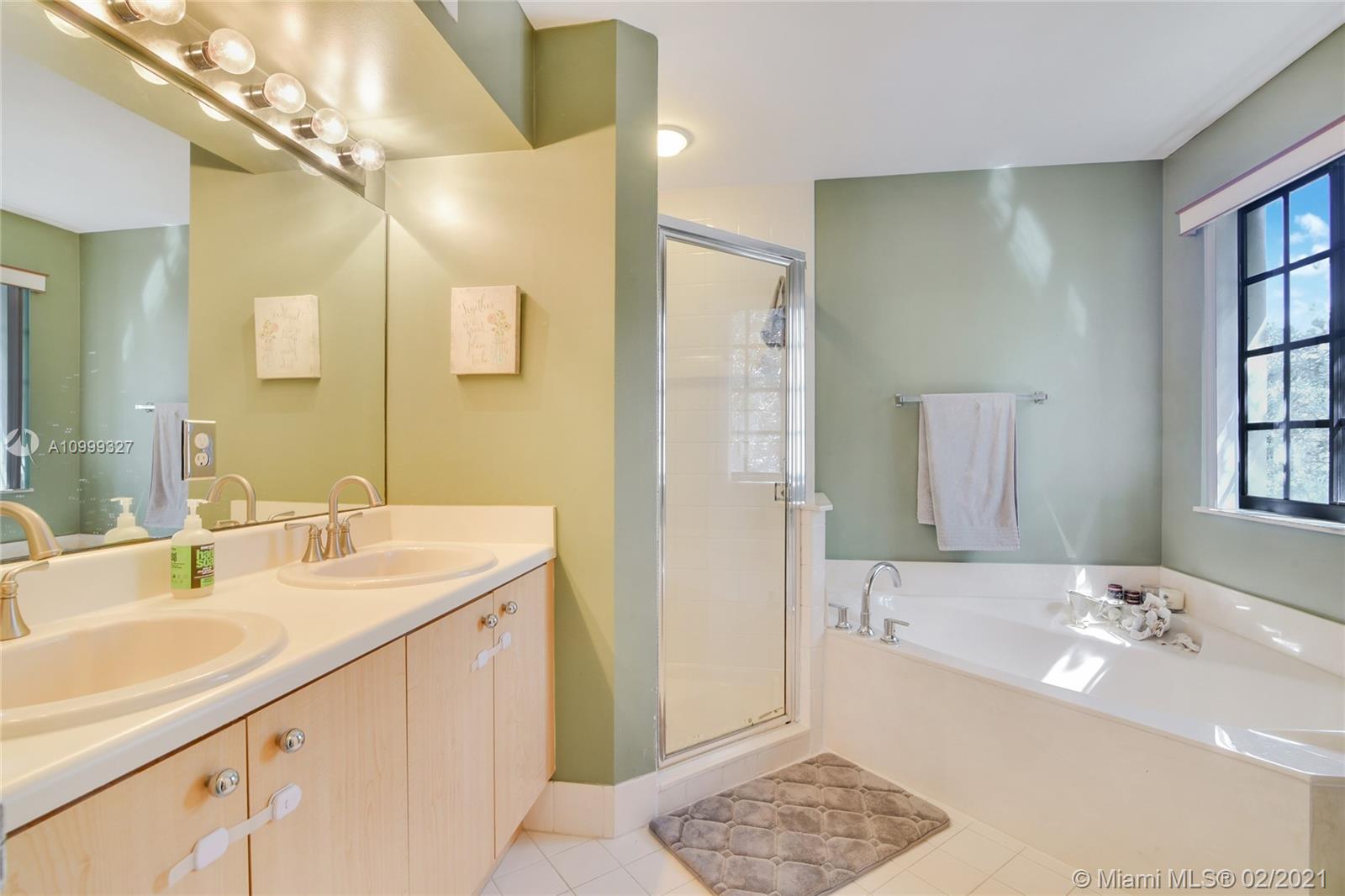 4100 Forest Drive, Unit 4100 Weston, FL 33332 - Photo 9 of 14 a bathroom with a double vanity sink a mirror and a bathtub