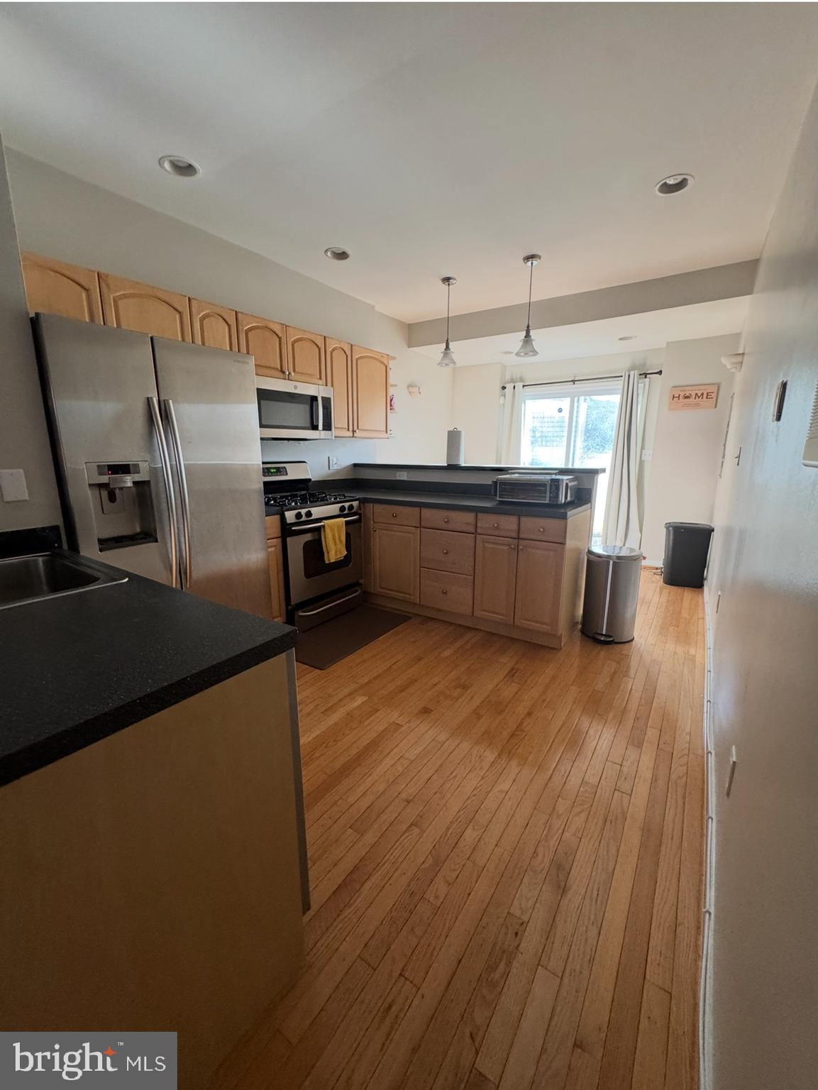 1746 South Hanover Street Baltimore, MD 21230 - Photo 3 of 19 a kitchen with stainless steel appliances wooden floor and a refrigerator