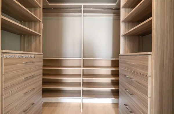 a view of walk in closet with empty racks