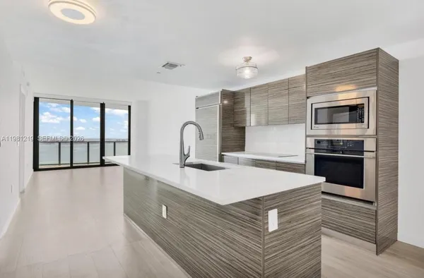 a kitchen with a sink appliances and cabinets