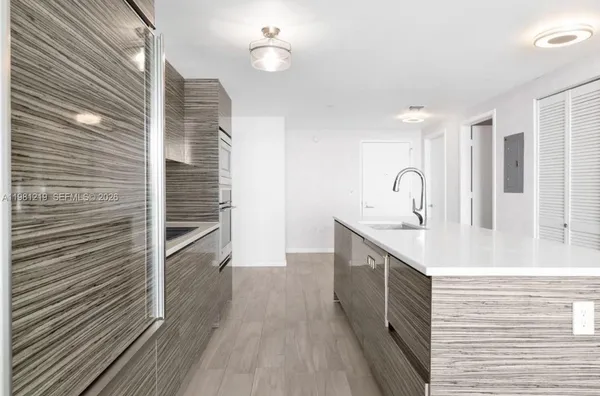 a kitchen with a sink and wooden floor