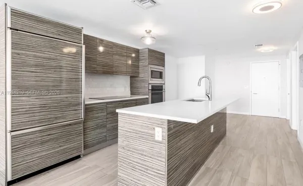 a kitchen with a sink and a wooden floor