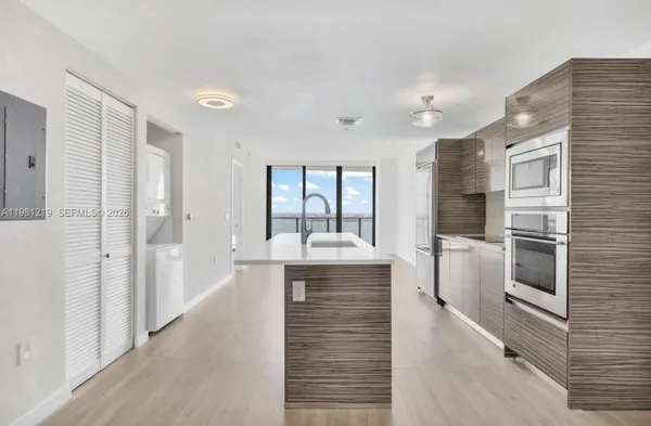 a large white kitchen with a large window