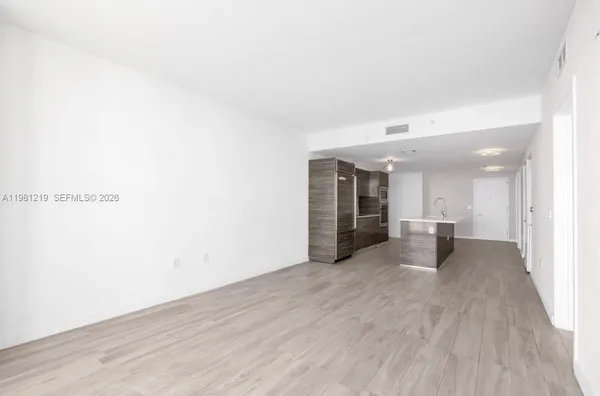 a view of a livingroom with wooden floor and staircase