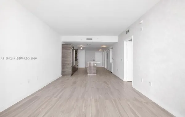 a view of a big room with wooden floor and a window