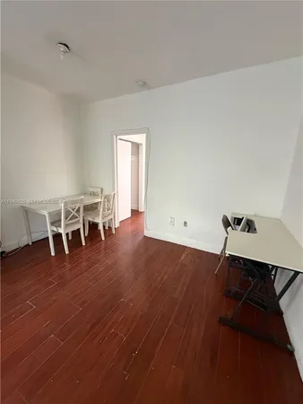 a view of a room with wooden floor lounge chair and a table