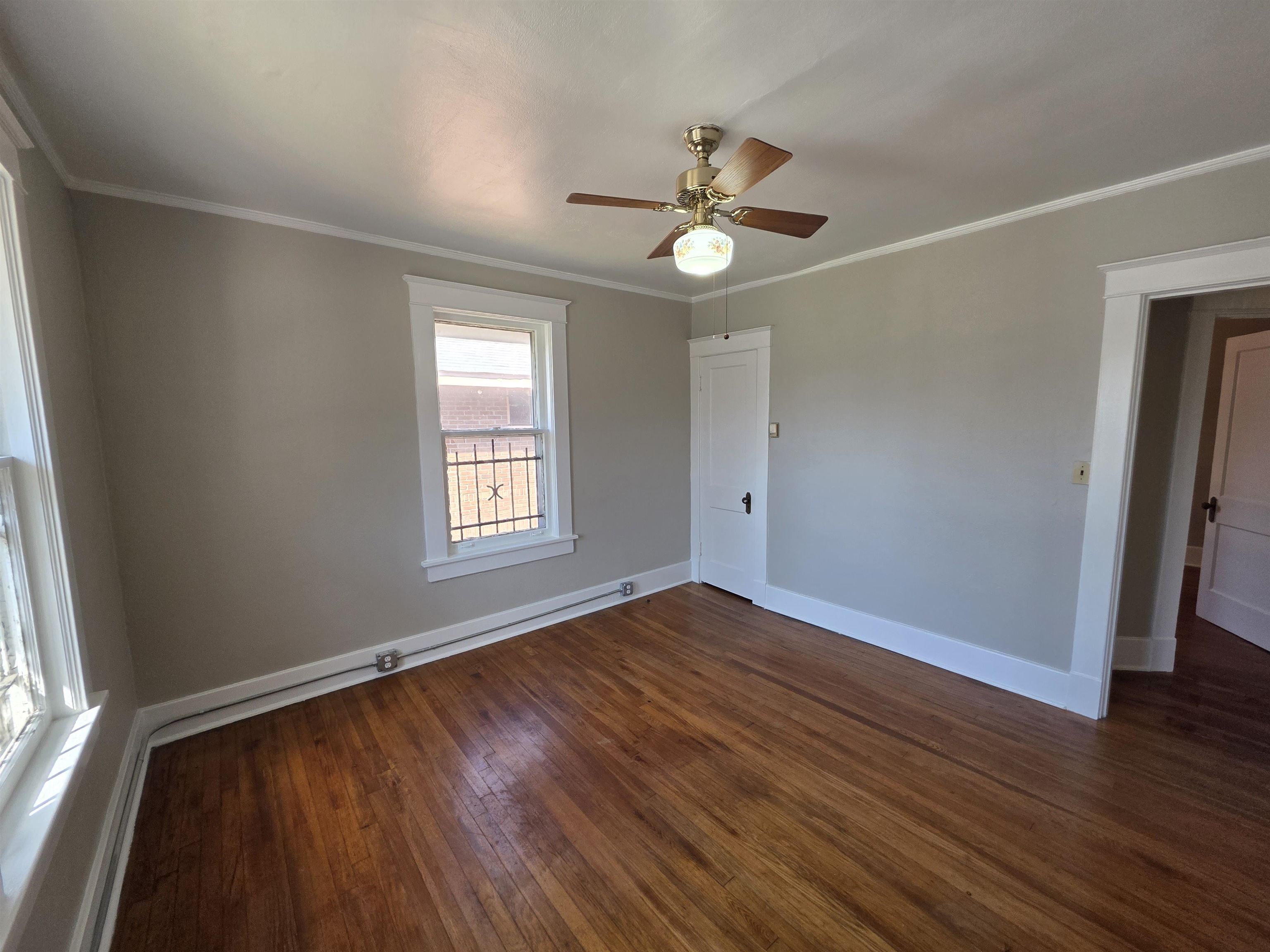 1404 Cameron Street Memphis, TN 38106 - Photo 12 of 37 an empty room with wooden floor fan and windows