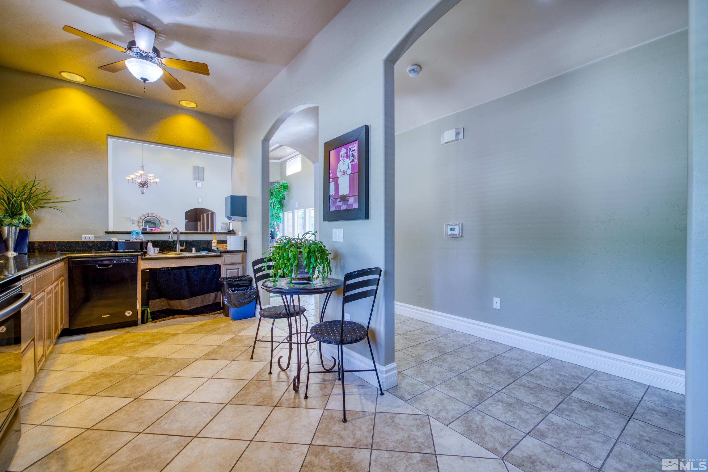 6850 Sharlands Avenue, Unit 2120 Reno, NV 89523 - Photo 30 of 35 a living room with couches a dining table and chairs with potted plants