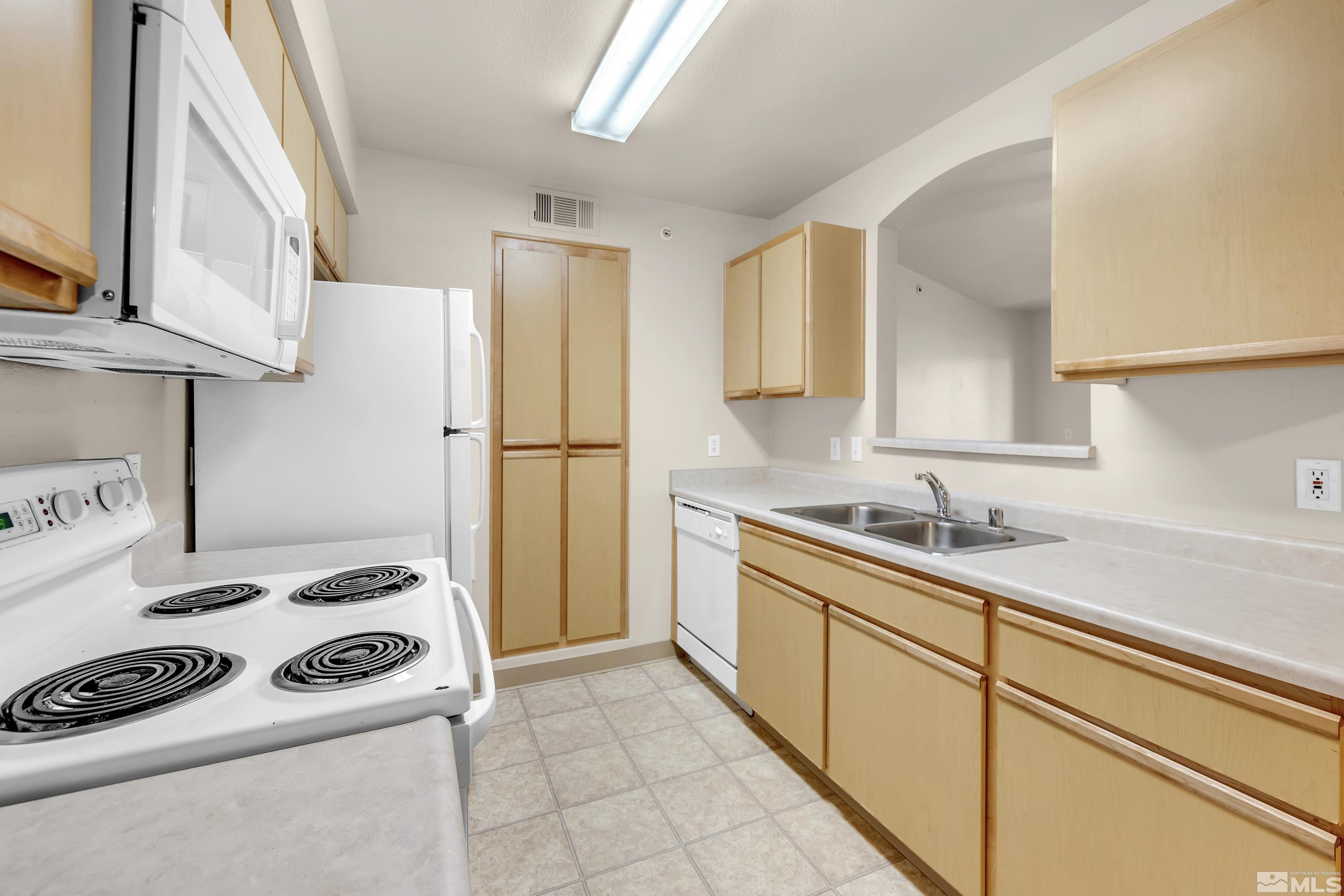 6850 Sharlands Avenue, Unit 2120 Reno, NV 89523 - Photo 4 of 35 a kitchen with a sink a stove and a refrigerator