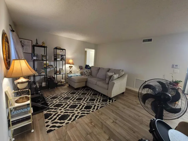 a living room with furniture and a wooden floor