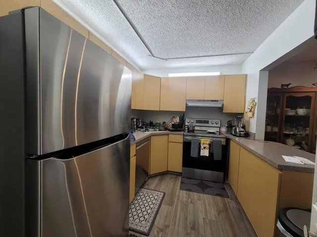 a kitchen with a refrigerator a sink and cabinets