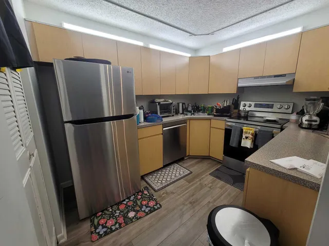 a kitchen with stainless steel appliances granite countertop a refrigerator stove and sink
