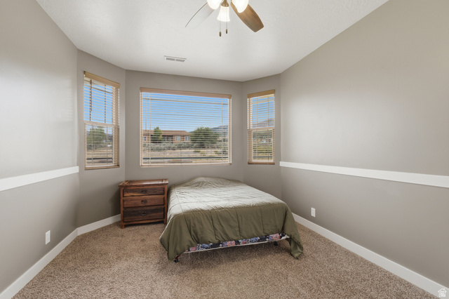 2567 West Rim Rock Drive Stockton, UT 84071 - Photo 28 of 64 Carpeted room featuring multiple windows with blinds, a ceiling fan, and baseboard trim