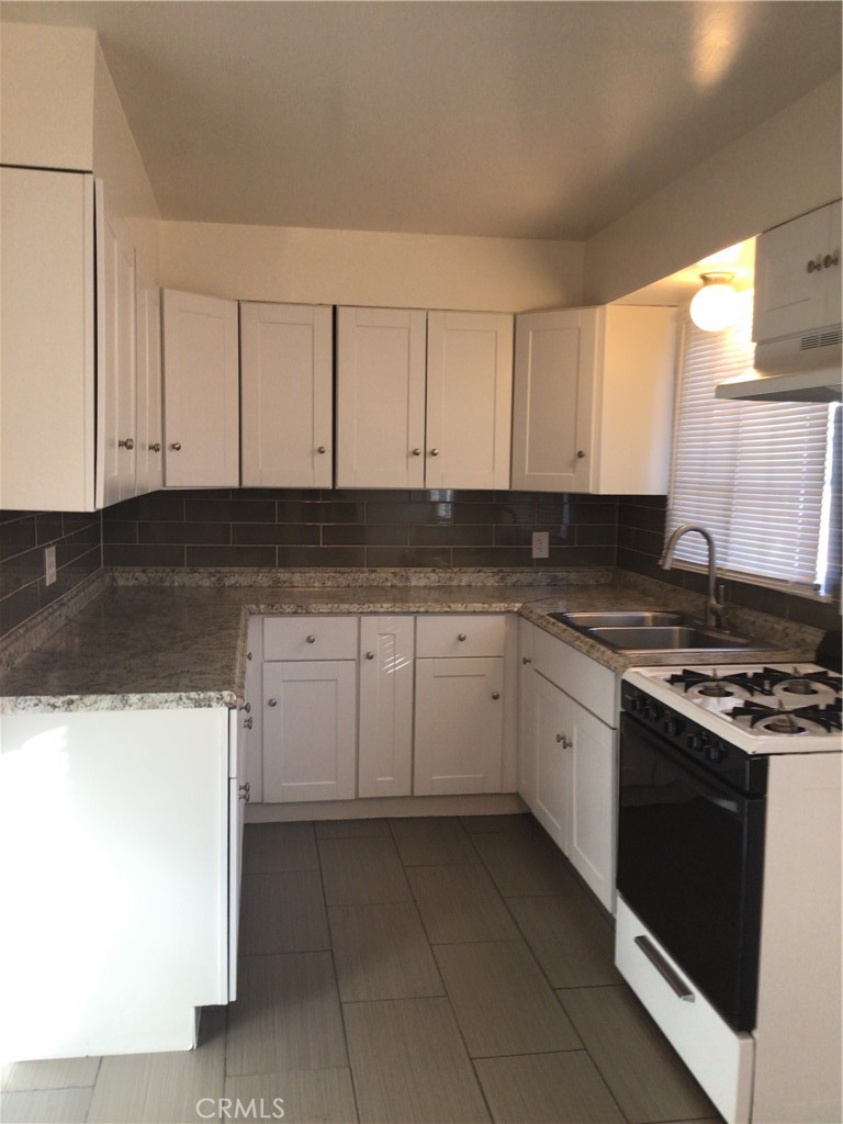1202 West Lumber Street Lancaster, CA 93534 - Photo 8 of 16 a kitchen with granite countertop white cabinets and stainless steel appliances