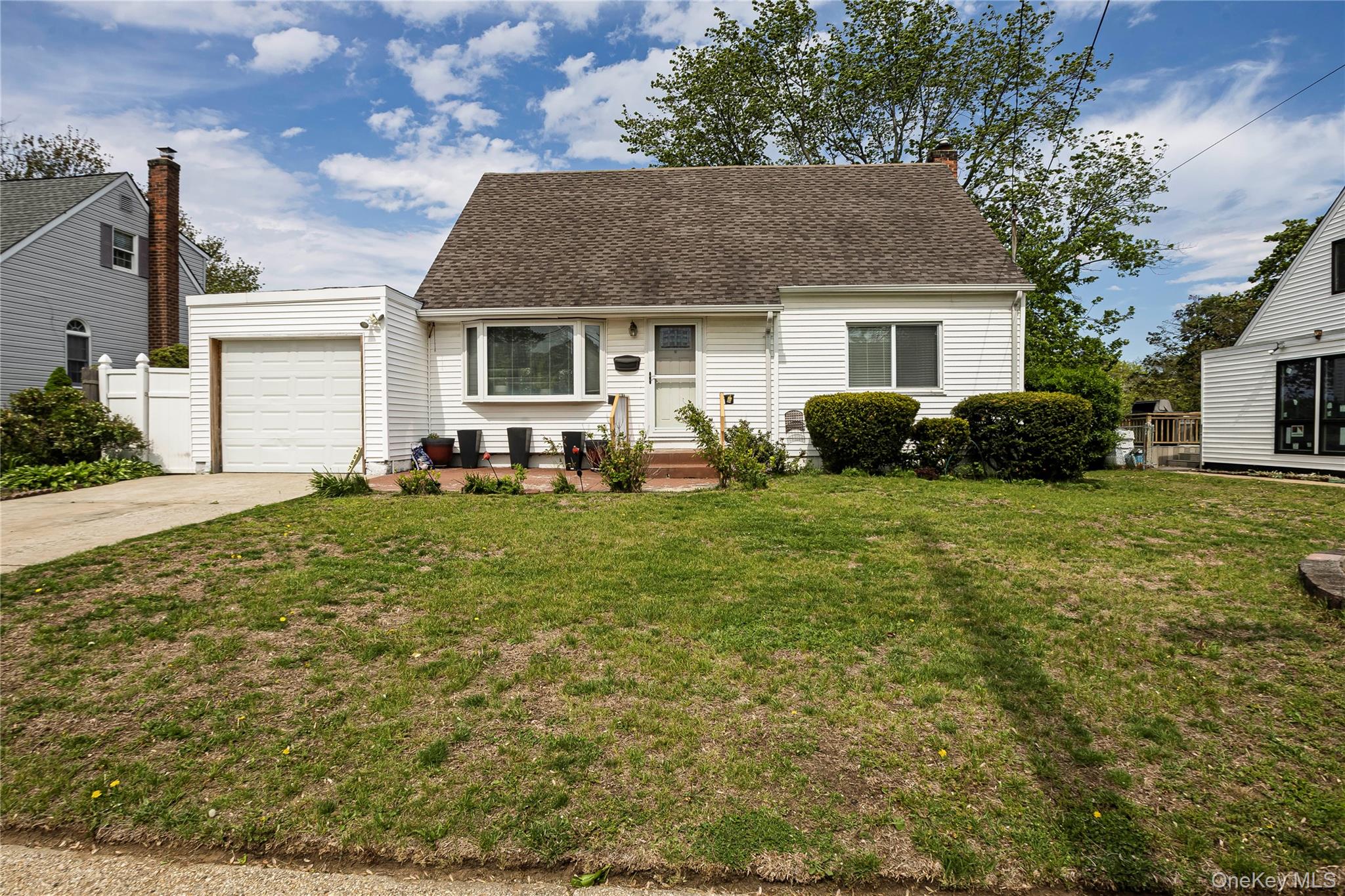 a front view of a house with a yard and trees