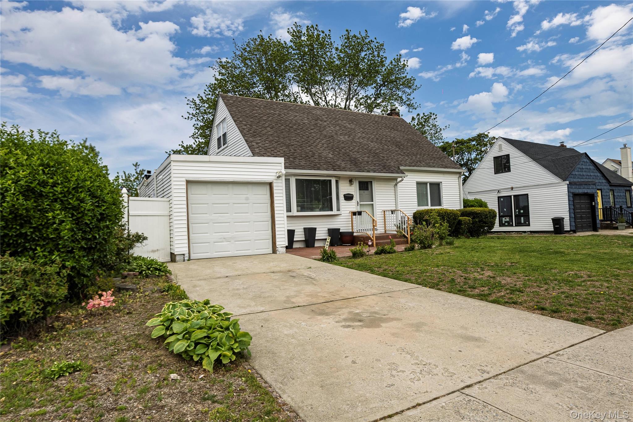 2687 Fox Road Baldwin, NY 11510 - Photo 4 of 27 a front view of a house with a yard and garage