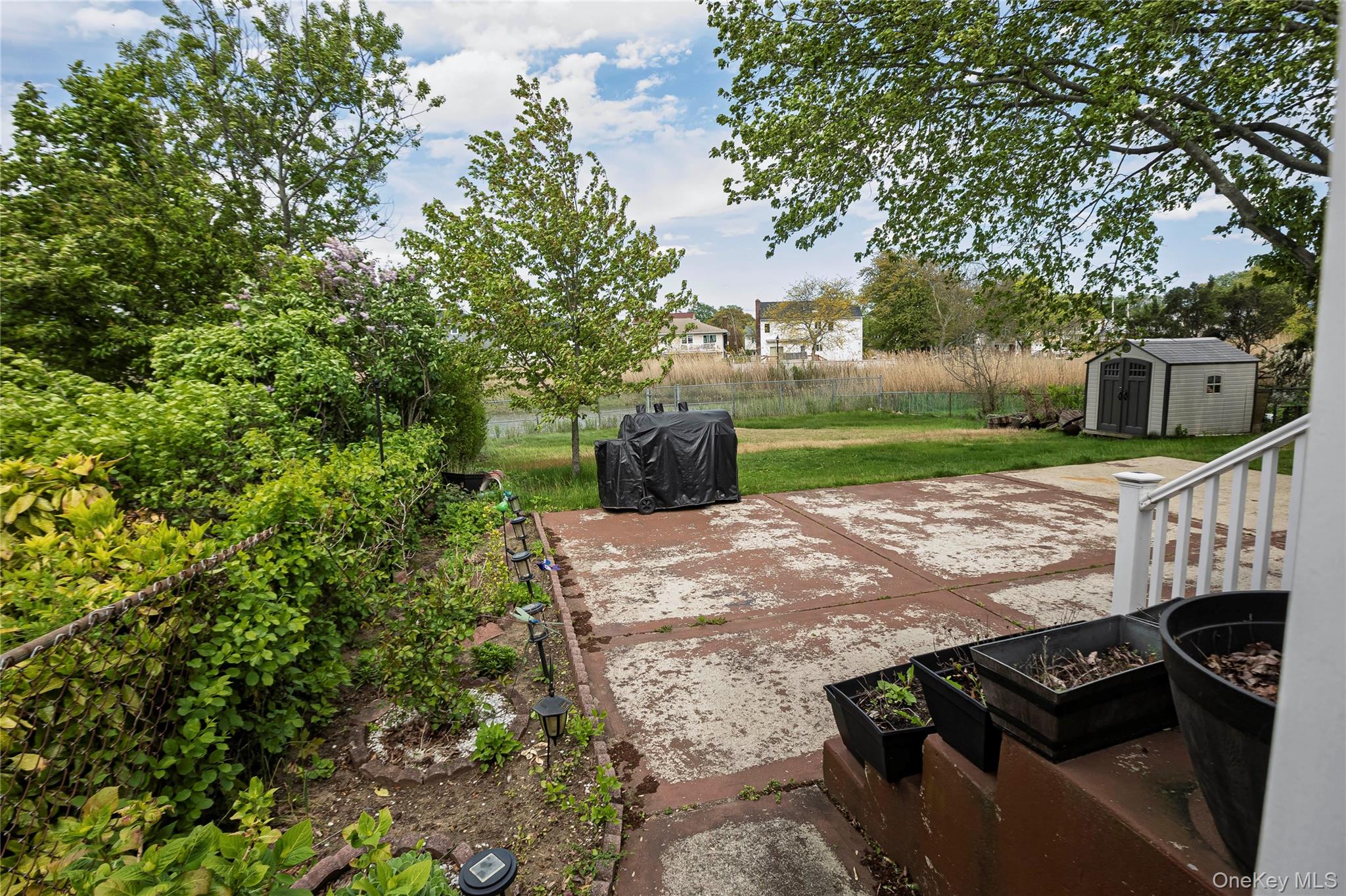 2687 Fox Road Baldwin, NY 11510 - Photo 5 of 27 a view of a backyard with couches plants and large trees