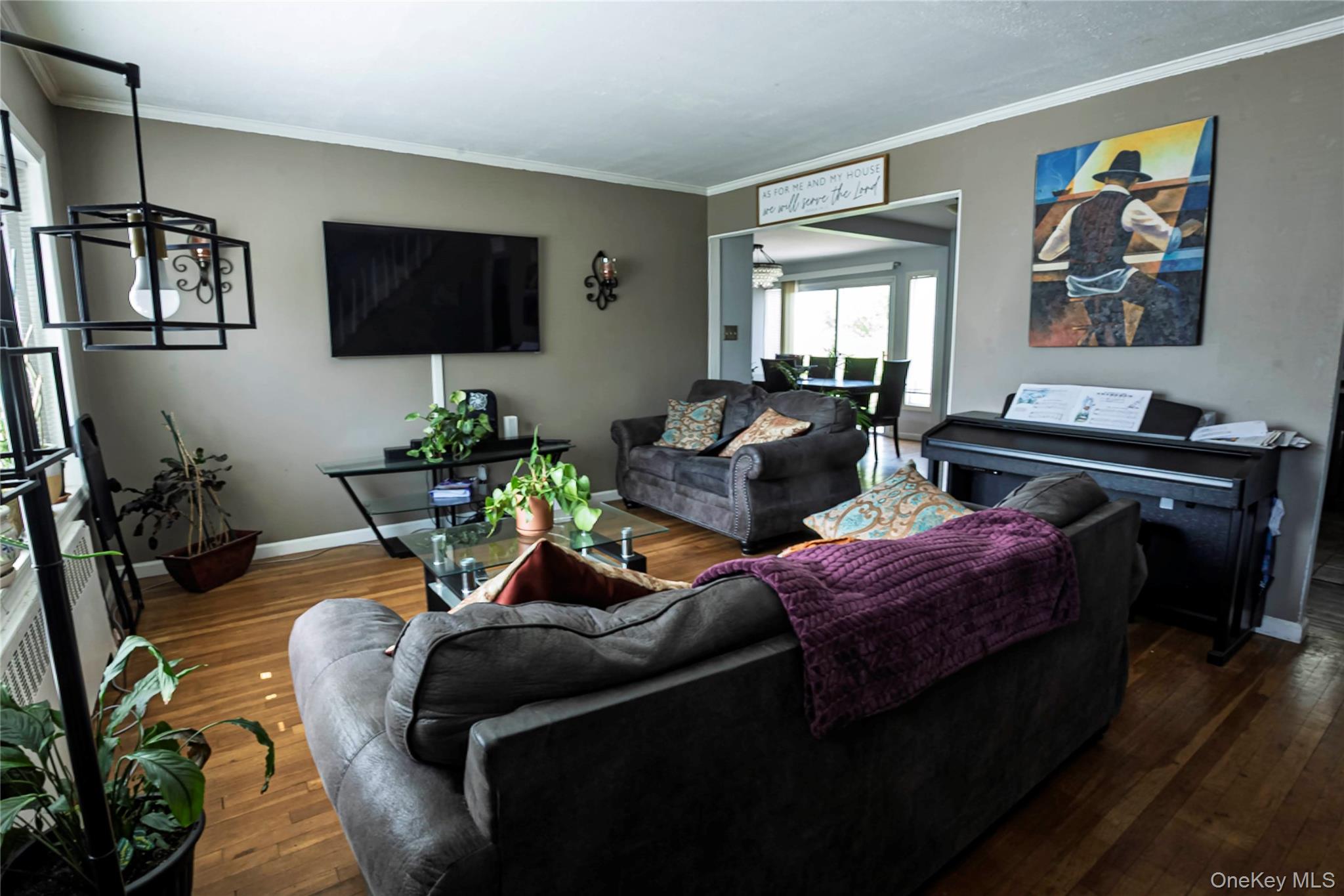 2687 Fox Road Baldwin, NY 11510 - Photo 9 of 27 a living room with furniture a flat screen tv and paintings on the wall