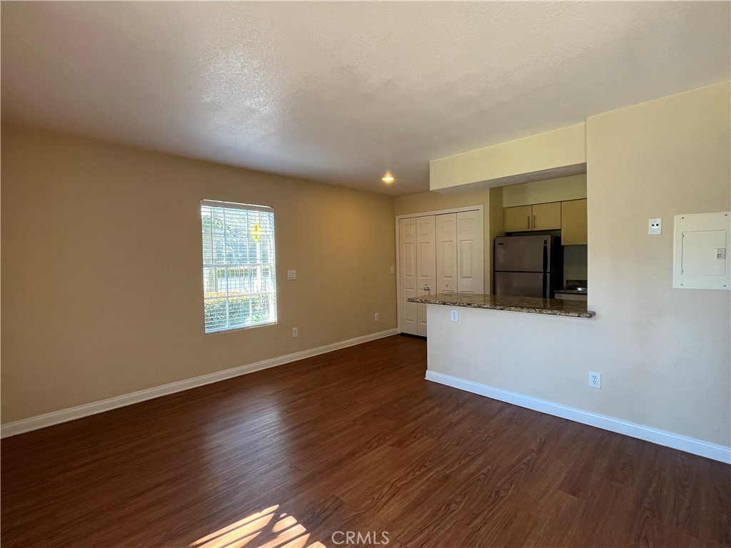 2160 Highpointe Drive, Unit 112 Corona, CA 92879 - Photo 4 of 21 a view of an empty room with wooden floor and a window