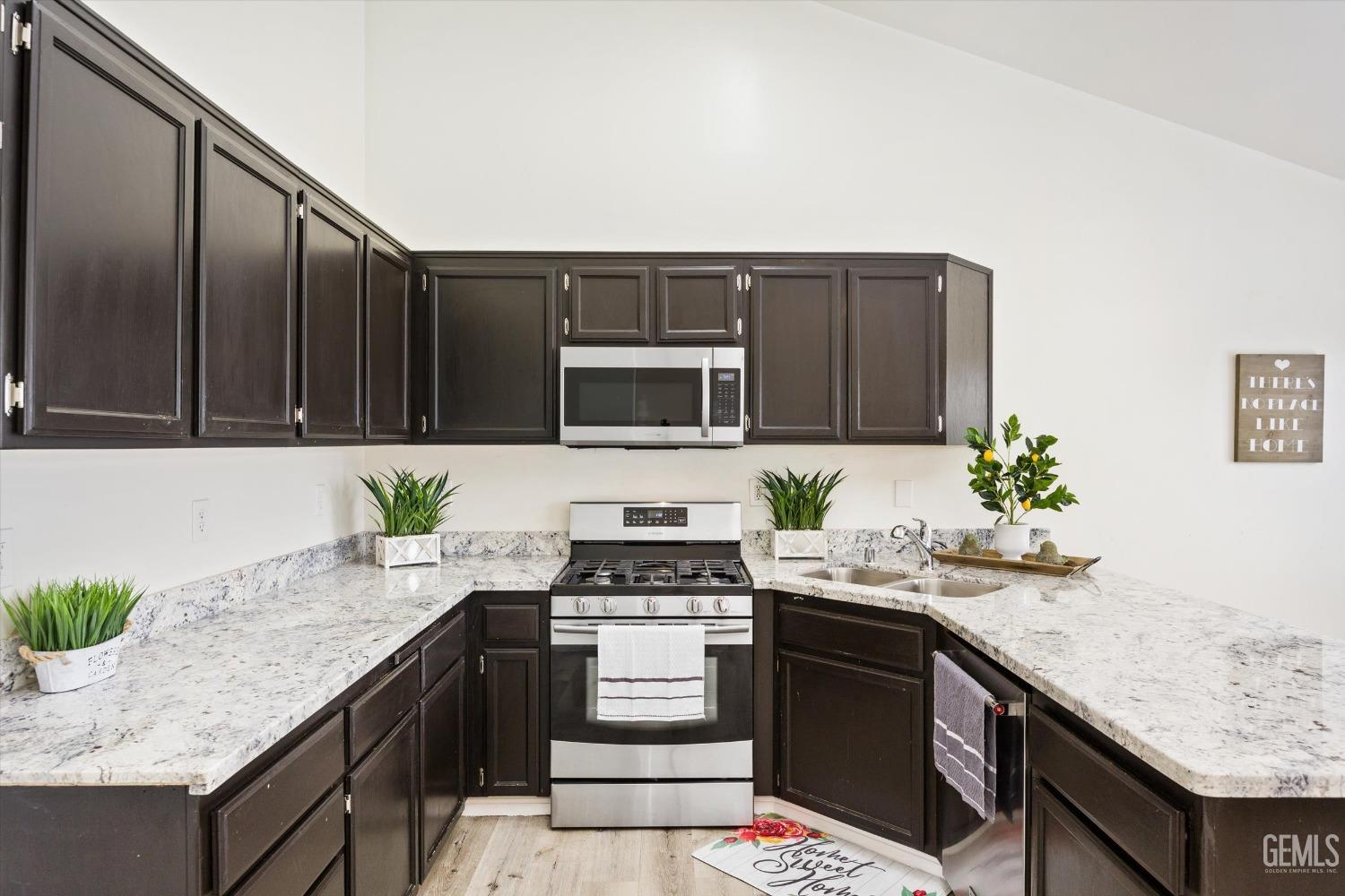 Undisclosed Address Bakersfield, CA 93307 - Photo 11 of 35 a kitchen with granite countertop a sink cabinets and stainless steel appliances