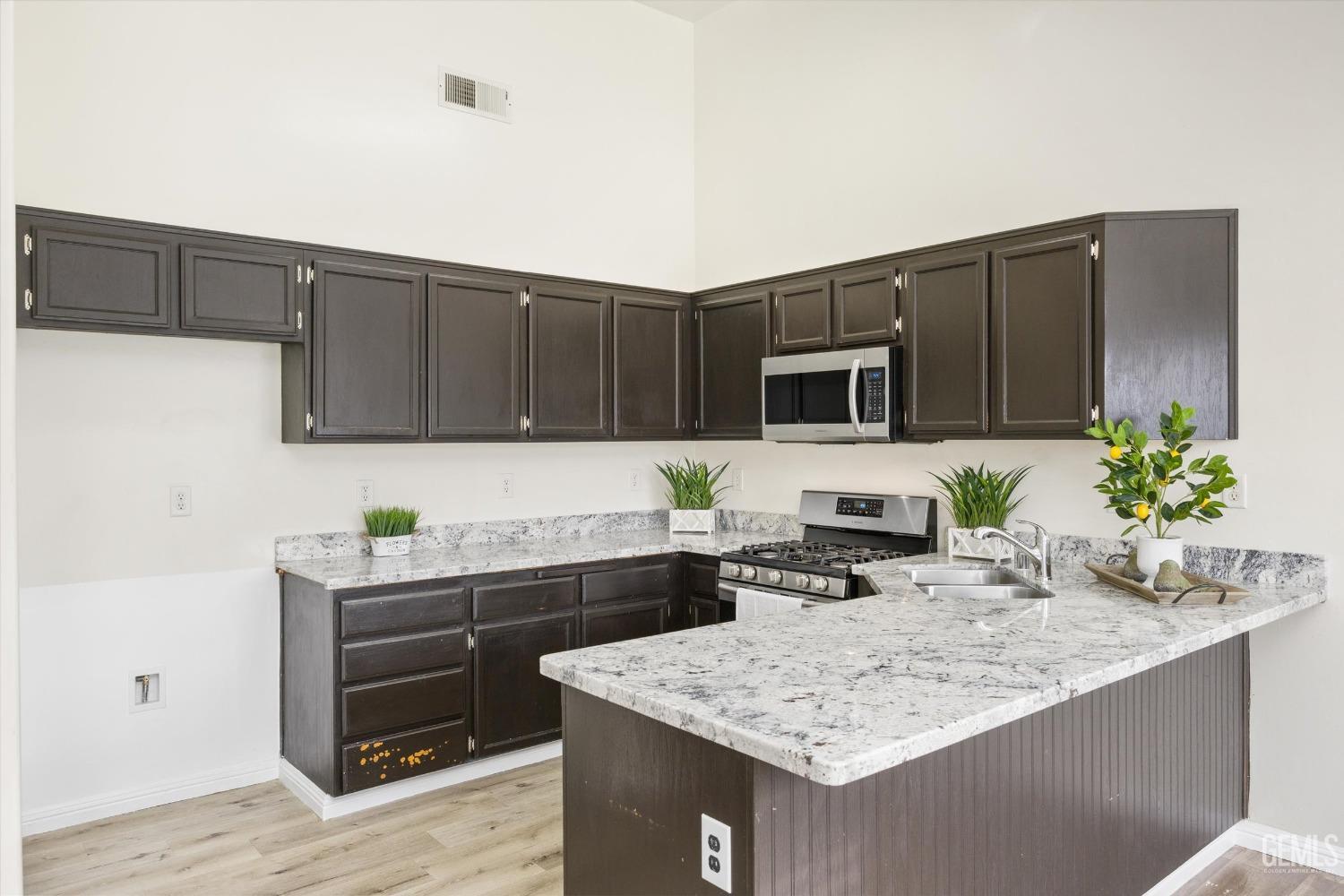 Undisclosed Address Bakersfield, CA 93307 - Photo 13 of 35 a kitchen with stainless steel appliances granite countertop a sink stove and refrigerator