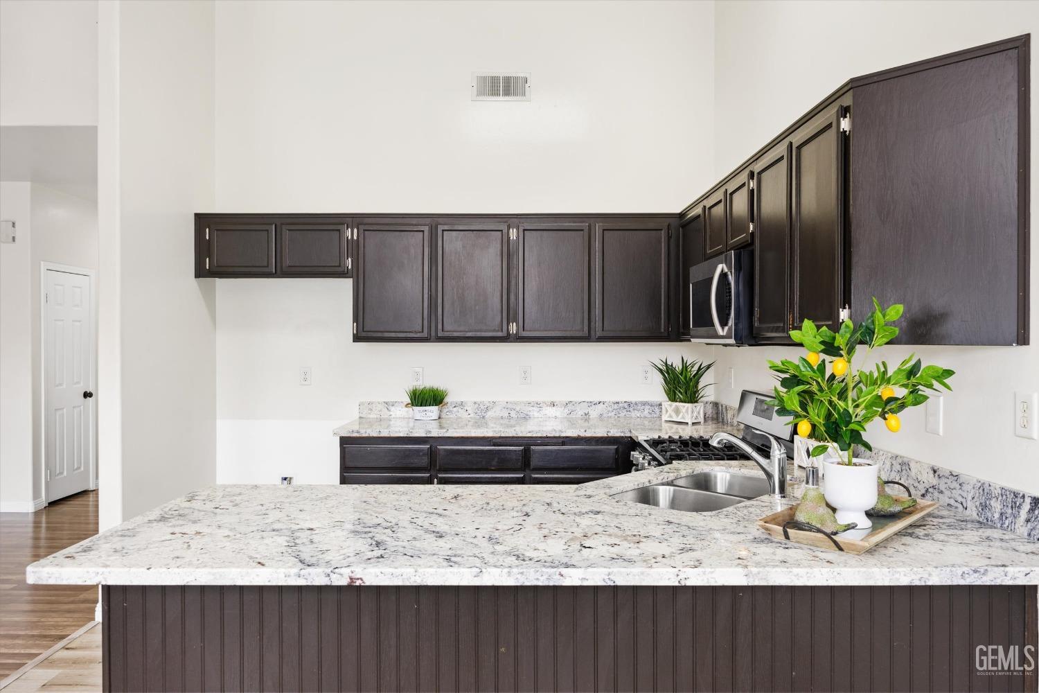 Undisclosed Address Bakersfield, CA 93307 - Photo 14 of 35 a kitchen with a sink a stove and cabinets