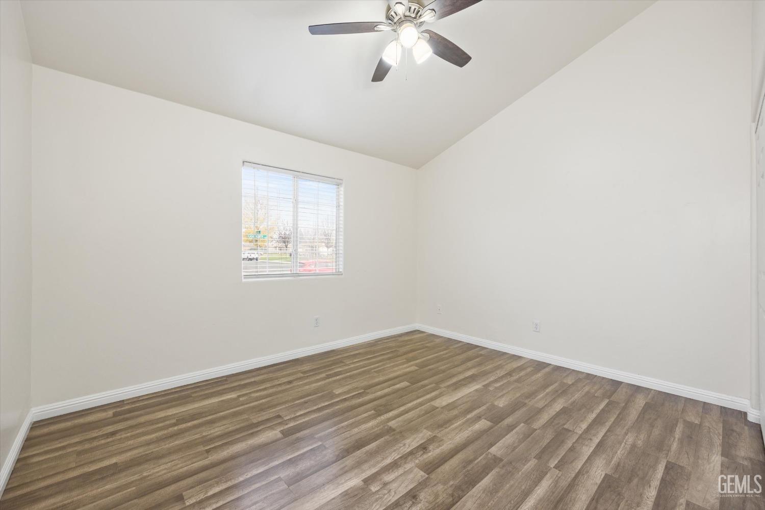 Undisclosed Address Bakersfield, CA 93307 - Photo 19 of 35 an empty room with wooden floor fan and windows