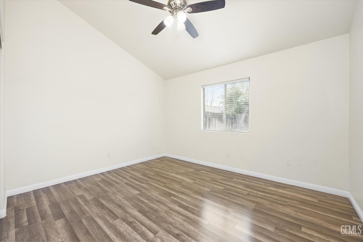 Undisclosed Address Bakersfield, CA 93307 - Photo 22 of 35 an empty room with wooden floor and ceiling fan
