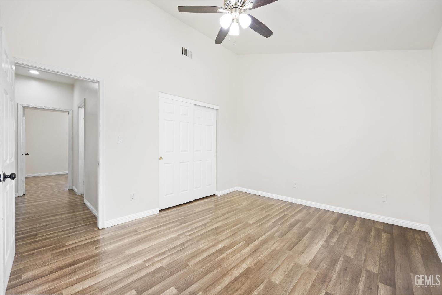 Undisclosed Address Bakersfield, CA 93307 - Photo 24 of 35 an empty room with wooden floor fan and windows